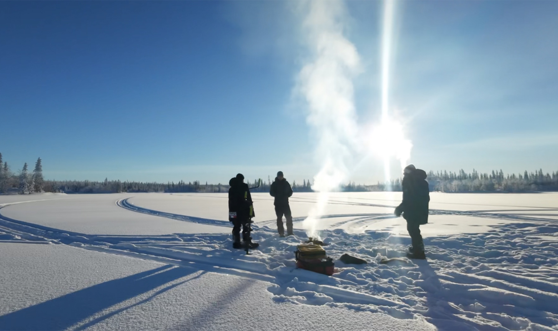 Ice fishing on a frozen lake in Swedish Lapland